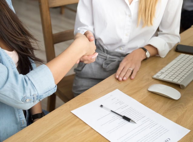 Two women partners handshaking after signing business contract at meeting, female client or customer and manager agent broker closing good deal, female hands shaking making agreement, close up view